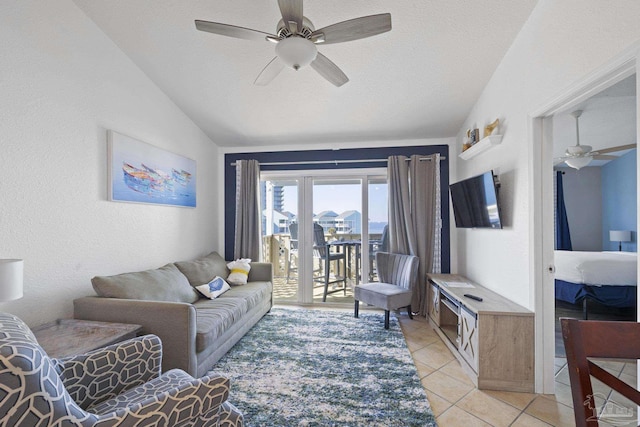 living room featuring ceiling fan, vaulted ceiling, a textured ceiling, and light tile patterned floors