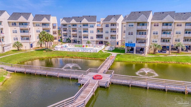 dock area featuring a lawn and a water view