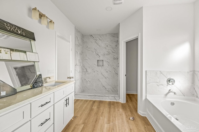 bathroom with plus walk in shower, vanity, and hardwood / wood-style flooring