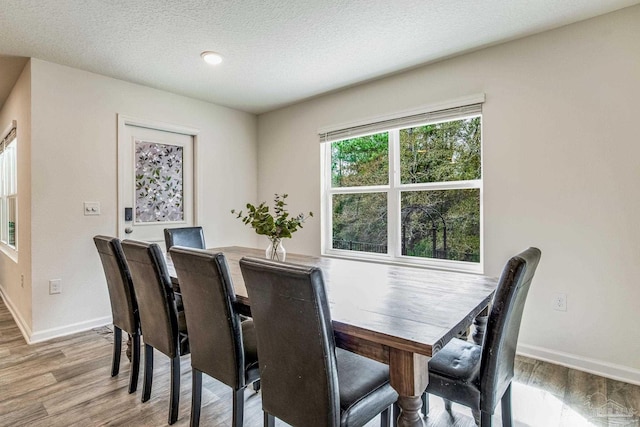 dining space featuring a textured ceiling and light hardwood / wood-style floors