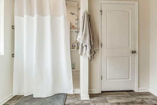 bathroom with hardwood / wood-style flooring and walk in shower