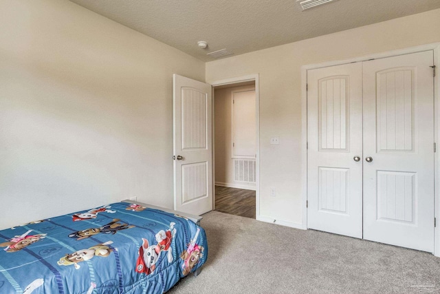 bedroom featuring carpet flooring, a textured ceiling, and a closet