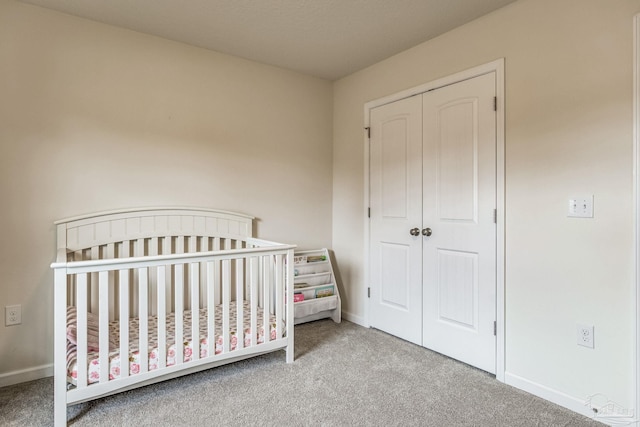 bedroom featuring a nursery area, carpet floors, and a closet