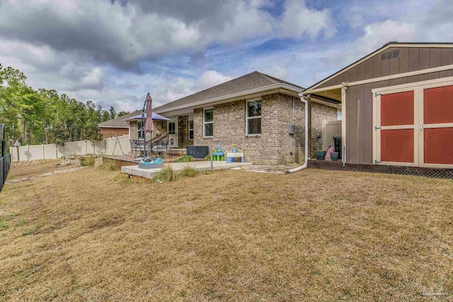 back of property with a storage shed, a yard, a patio area, and central air condition unit