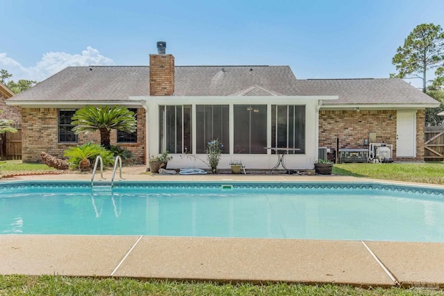 view of swimming pool featuring a sunroom