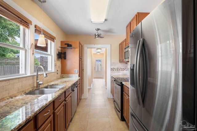 kitchen with appliances with stainless steel finishes, pendant lighting, sink, backsplash, and light tile patterned floors