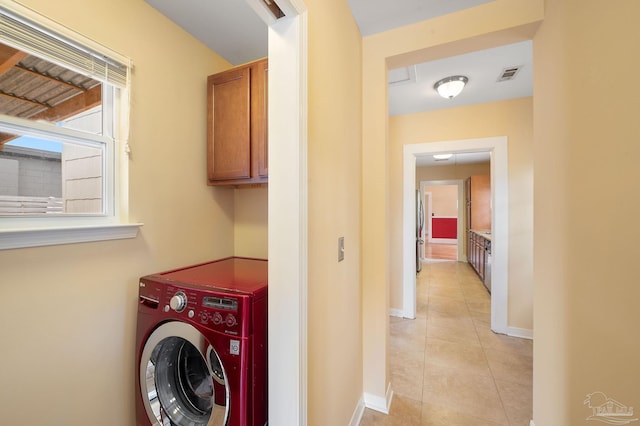 laundry room featuring cabinets, light tile patterned floors, and washer / clothes dryer