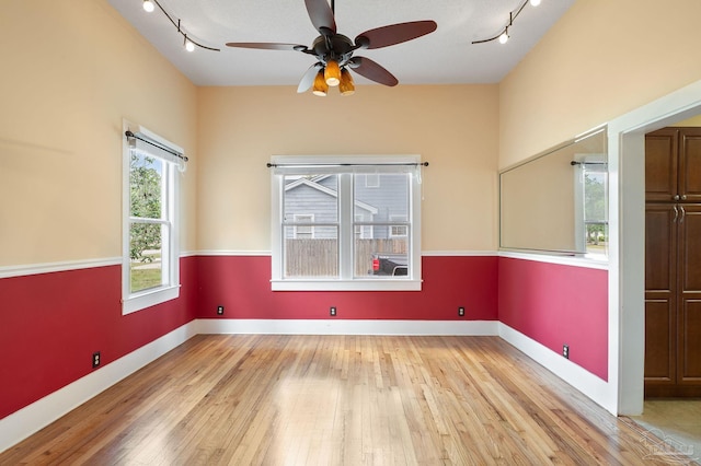 spare room featuring light hardwood / wood-style floors, rail lighting, and ceiling fan