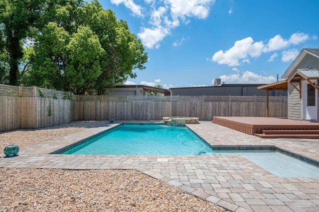 view of swimming pool featuring pool water feature, an in ground hot tub, and a deck