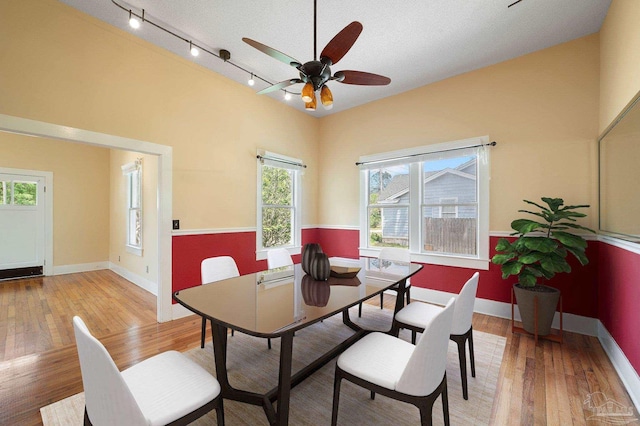 dining space with ceiling fan, a textured ceiling, and light hardwood / wood-style floors