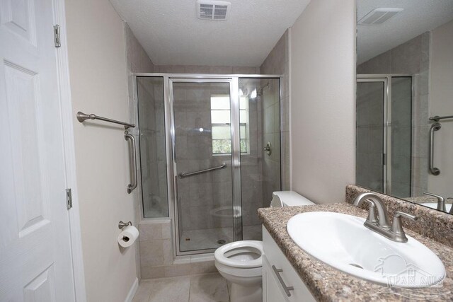 bathroom featuring vanity, tile patterned floors, walk in shower, toilet, and a textured ceiling