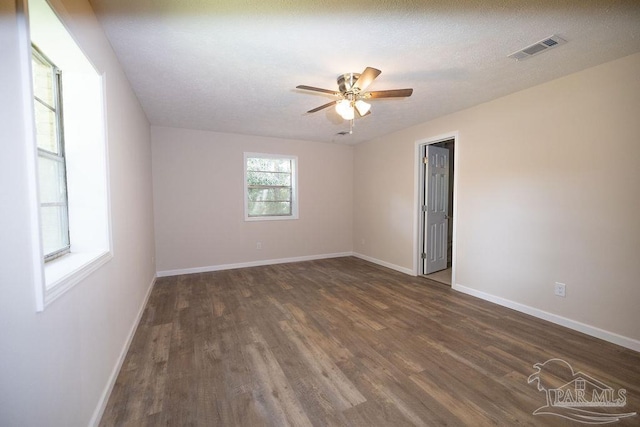 empty room with ceiling fan, dark hardwood / wood-style flooring, and a textured ceiling