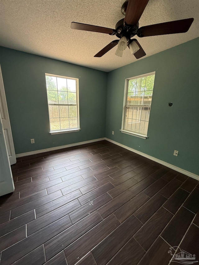 7030 Mcelhaney Rd, Century, FL 32535 - empty room with wood finish floors, healthy amount of natural light, a ceiling fan, and a textured ceiling