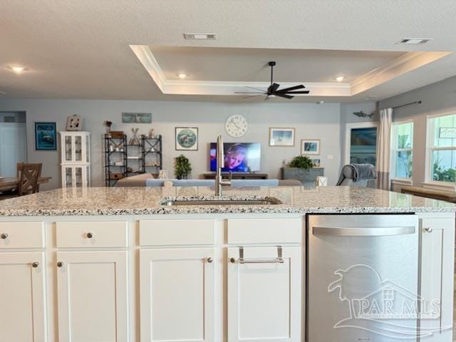 kitchen featuring white cabinets, dishwasher, and a raised ceiling