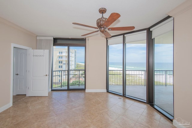 tiled spare room featuring crown molding, a water view, floor to ceiling windows, and ceiling fan