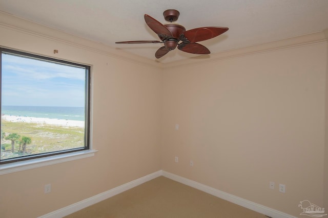 empty room featuring a water view, ceiling fan, and carpet