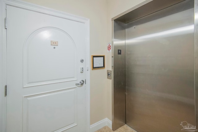 doorway to outside featuring elevator and light tile patterned flooring