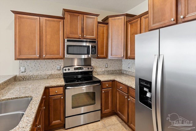 8868 Sanderling Ln, Navarre, FL 32566 - kitchen with appliances with stainless steel finishes, brown cabinetry, and decorative backsplash