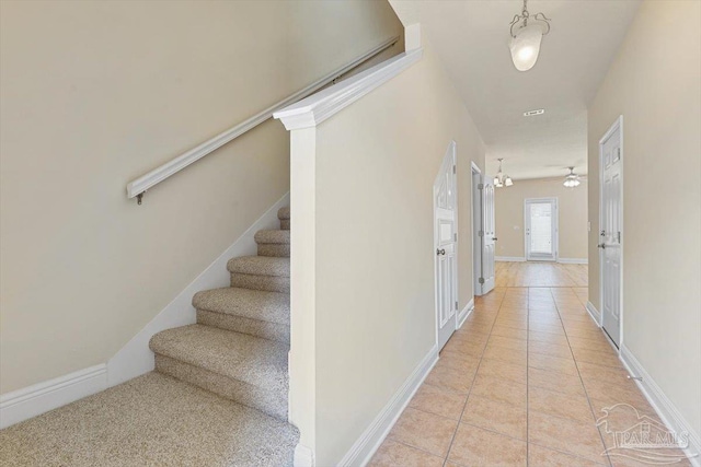 8868 Sanderling Ln, Navarre, FL 32566 - corridor featuring stairway, light tile patterned flooring, and baseboards