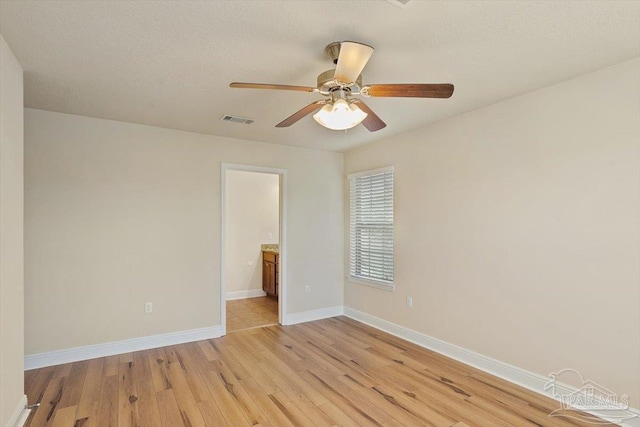 8868 Sanderling Ln, Navarre, FL 32566 - unfurnished bedroom with light wood-style flooring, baseboards, connected bathroom, and a ceiling fan