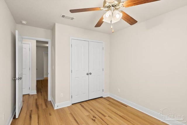 8868 Sanderling Ln, Navarre, FL 32566 - unfurnished bedroom with light wood-style flooring, baseboards, a closet, and a ceiling fan