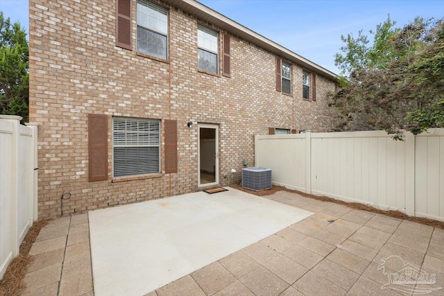 8868 Sanderling Ln, Navarre, FL 32566 - rear view of house featuring a patio, central air condition unit, and brick siding