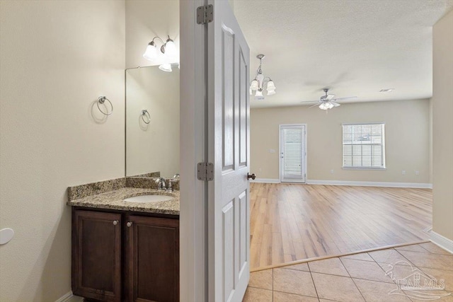 8868 Sanderling Ln, Navarre, FL 32566 - bathroom with vanity, a ceiling fan, wood finished floors, baseboards, and a chandelier