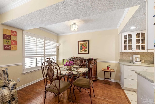 1650 Bulevar Menor, Pensacola Beach, FL 32561 - dining area with crown molding, a textured ceiling, and light wood-type flooring