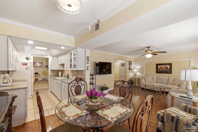1650 Bulevar Menor, Pensacola Beach, FL 32561 - dining space featuring crown molding, visible vents, ceiling fan, light wood-type flooring, and a textured ceiling