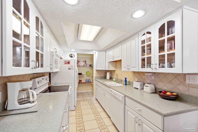 1650 Bulevar Menor, Pensacola Beach, FL 32561 - kitchen with light tile patterned flooring, a sink, white appliances, a textured ceiling, and white cabinetry