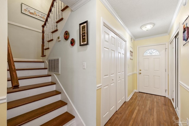 1650 Bulevar Menor, Pensacola Beach, FL 32561 - entryway featuring a textured ceiling, visible vents, ornamental molding, and hardwood / wood-style flooring