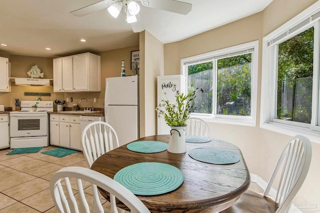 dining space featuring ceiling fan, light tile patterned flooring, and sink