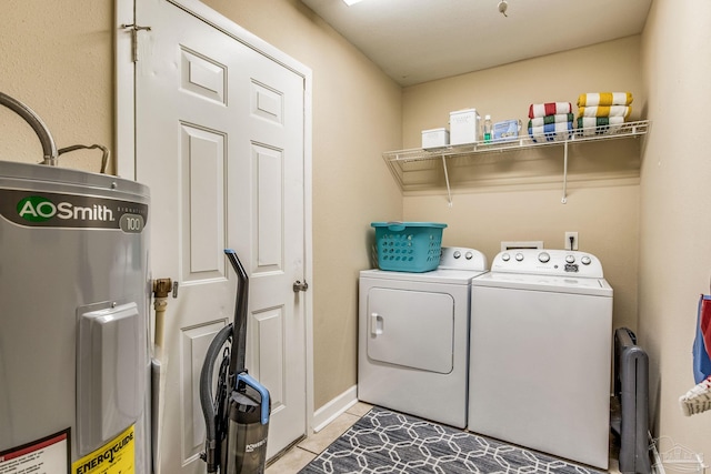 laundry area with washer and dryer, light tile patterned floors, and water heater