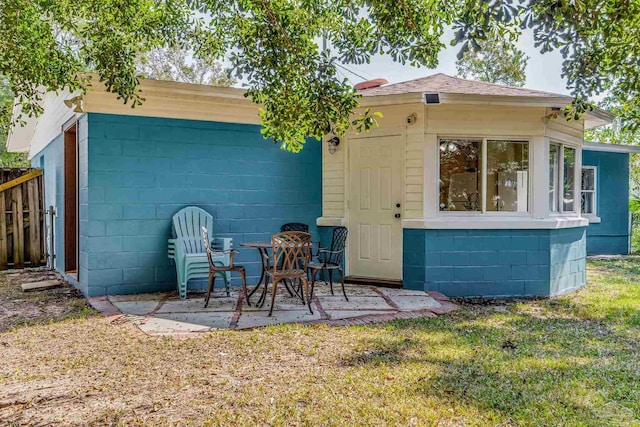 back of house featuring a patio and a lawn