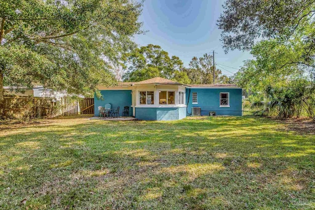 rear view of property featuring a lawn