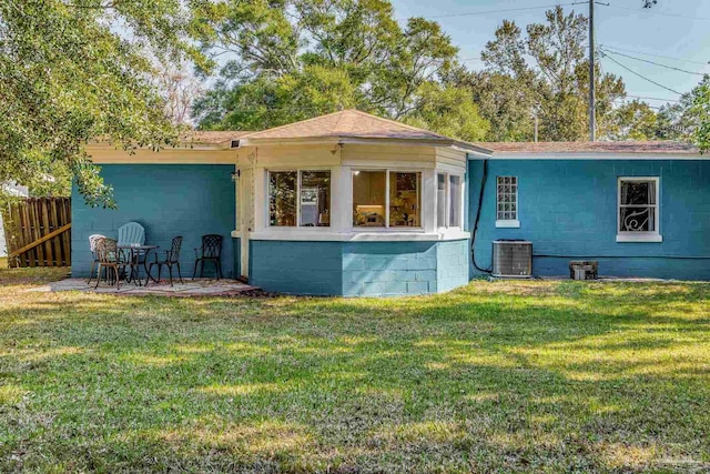 back of house featuring central AC and a lawn