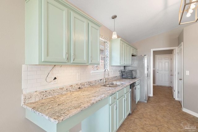 kitchen featuring appliances with stainless steel finishes, backsplash, sink, pendant lighting, and lofted ceiling