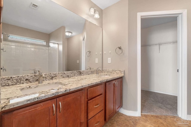 bathroom with tile patterned floors, vanity, and walk in shower