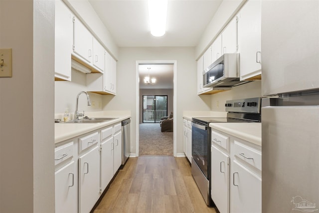 kitchen featuring white cabinetry, sink, a chandelier, light hardwood / wood-style floors, and appliances with stainless steel finishes