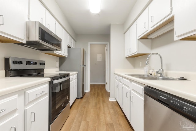 kitchen featuring sink, light wood-type flooring, white cabinetry, and stainless steel appliances