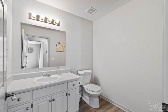 bathroom with vanity, a textured ceiling, toilet, and hardwood / wood-style flooring