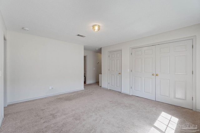 unfurnished bedroom featuring a textured ceiling and light colored carpet