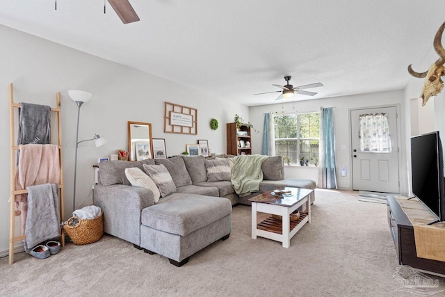 living room with ceiling fan, a textured ceiling, and light colored carpet