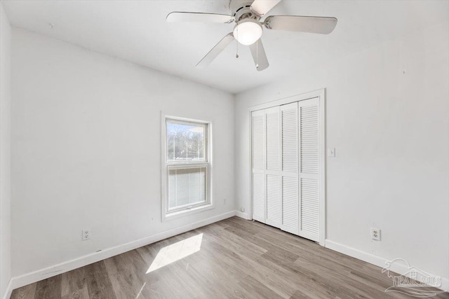 unfurnished bedroom featuring a ceiling fan, wood finished floors, a closet, and baseboards