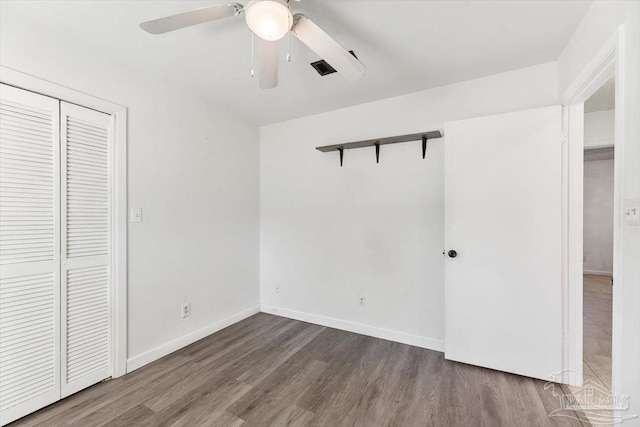 unfurnished bedroom with a closet, ceiling fan, baseboards, and wood finished floors