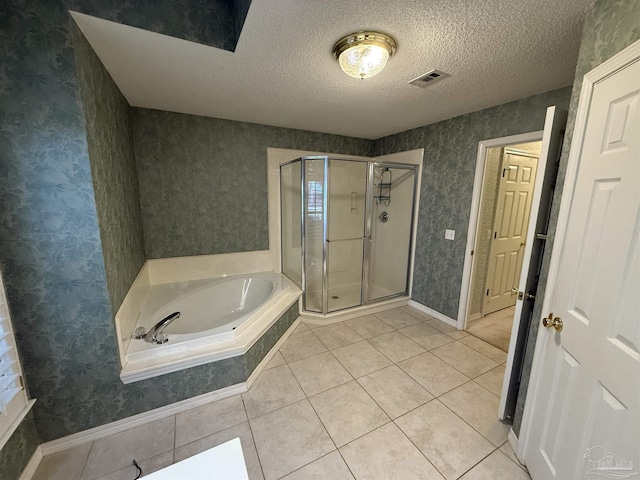 bathroom with plus walk in shower, a textured ceiling, and tile patterned floors