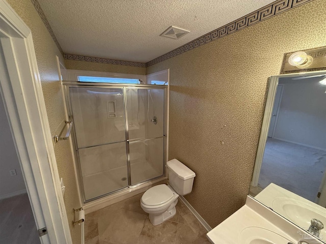 bathroom featuring vanity, a textured ceiling, tile patterned flooring, toilet, and a shower with shower door