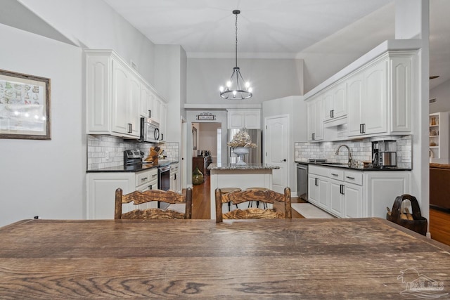 1333 Dubose Rd, Gulf Breeze, FL 32563 - kitchen with appliances with stainless steel finishes, a sink, dark countertops, and a chandelier
