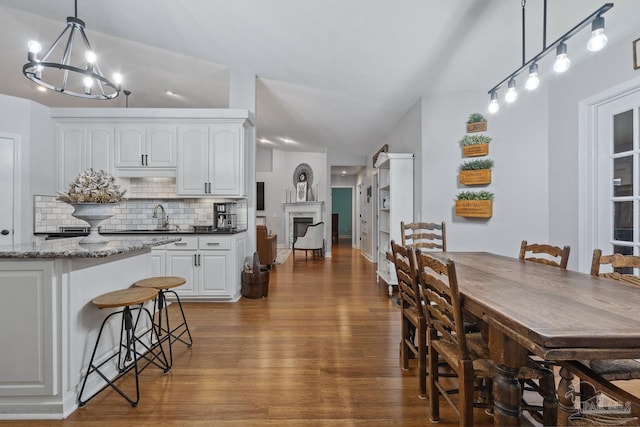 1333 Dubose Rd, Gulf Breeze, FL 32563 - dining space featuring wood finished floors, a chandelier, and vaulted ceiling