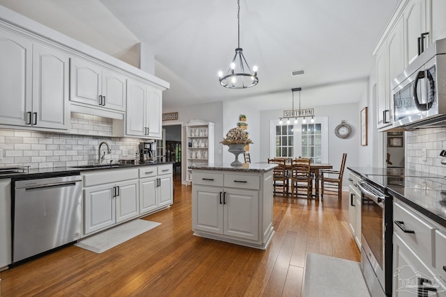 1333 Dubose Rd, Gulf Breeze, FL 32563 - kitchen featuring appliances with stainless steel finishes, a sink, a chandelier, backsplash, and decorative light fixtures